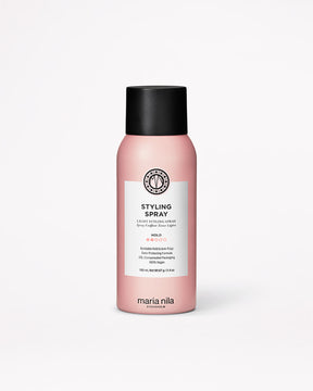 Pink bottle of Maria Nila styling spray on a white background