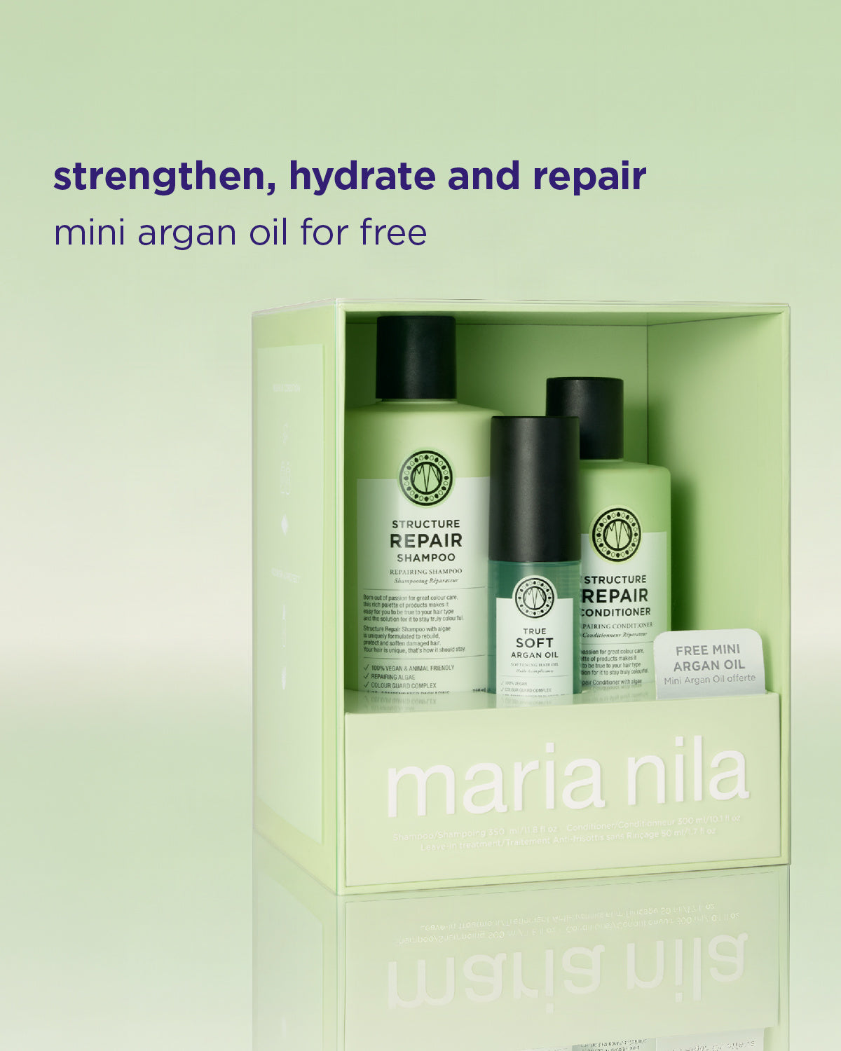 Maria Nila haircare set in a pale green box, featuring a shampoo bottle, a conditioner bottle, and a small free mini argan oil, with promotional text above on a matching pale green background.
