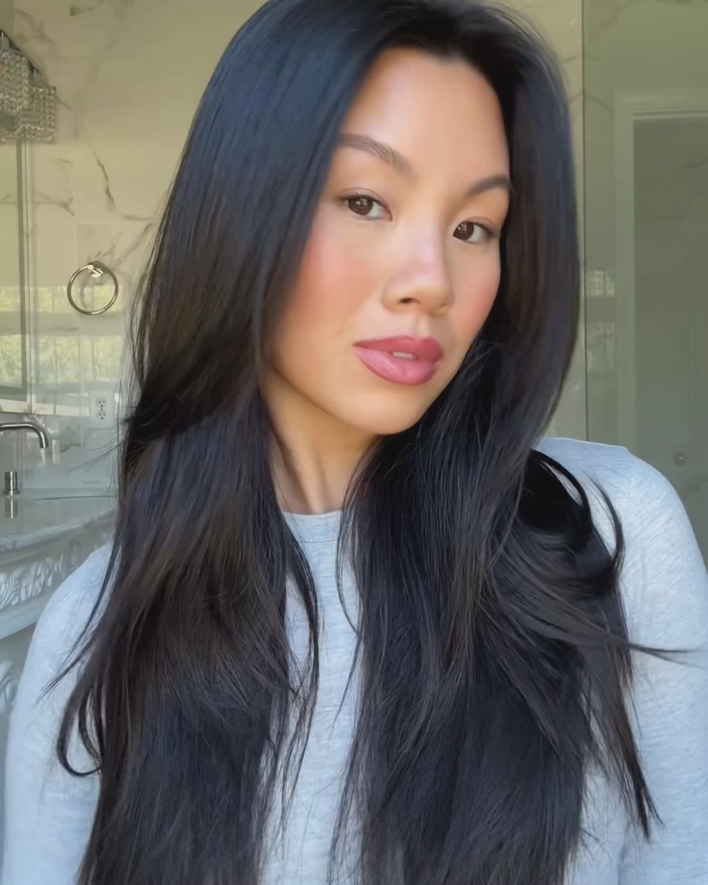 Woman with dark hair using the Maria Nila Gloss Coat